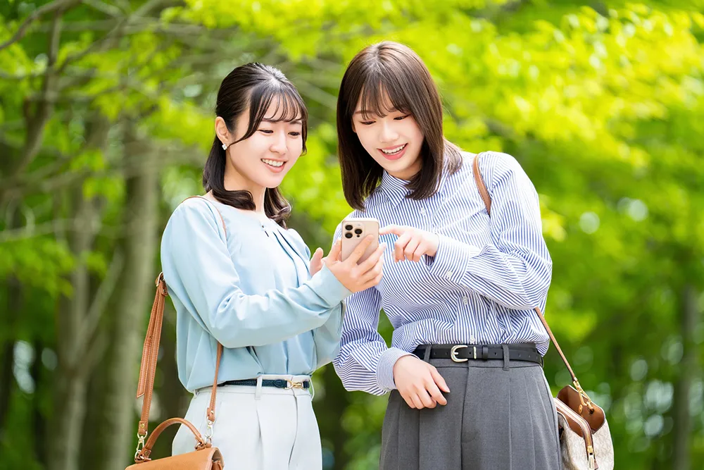 外出先でGoogleマップで店を探す若い女性たち